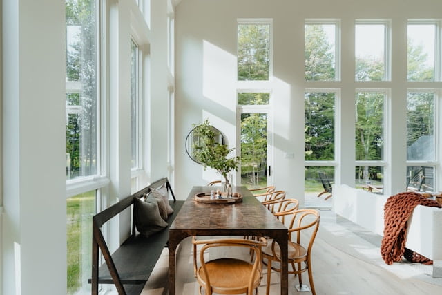 dining and living room in scandinavian style with natural light, wood elements natural texture, clean line furniture, plans and mirror 