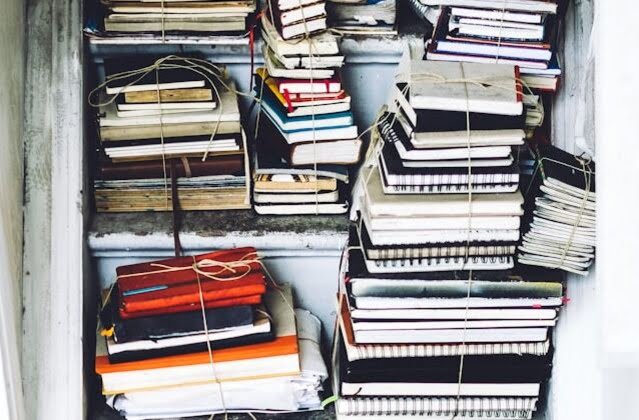 pile of books and note books grouped with rope around them, ready for donation