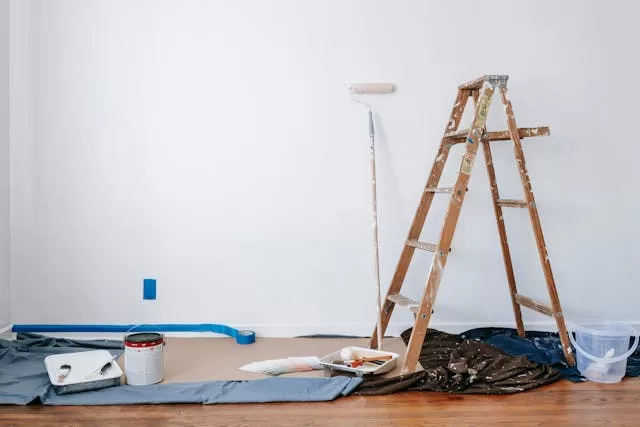 preparing painting tools and equipment and covered floor with drop cloths for DIY painting project