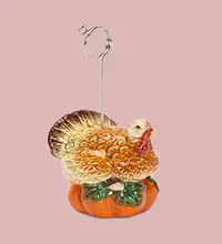 turkey perched on a pumpkin place card holder for Thanksgiving table setting 