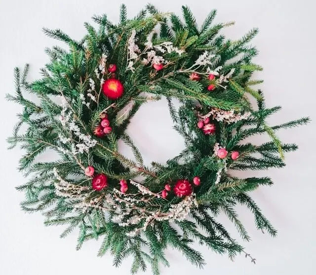 wreath with needles leave and small touches of berry as accept decor 