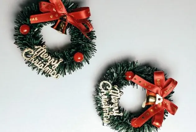 creative Christmas wreath in small size ribbon bows on top and merry Christmas sign 